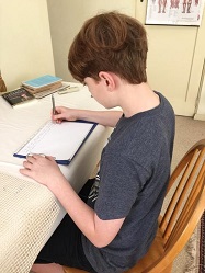 Boy writing after lessons